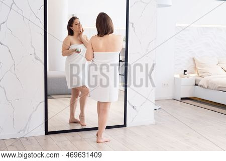 Adult Woman Apply Body Cream Look In Mirror At Home. Beauty And Lifestyle Concept.