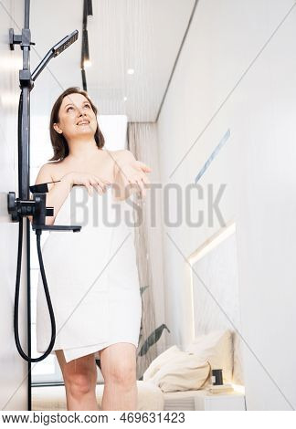 Smiling Woman Check Water Temperature In The Shower With Hand Shower Wall.