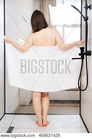 Chubby Woman In The Shower Room Drying Off And Wrapping Herself In A White Towel