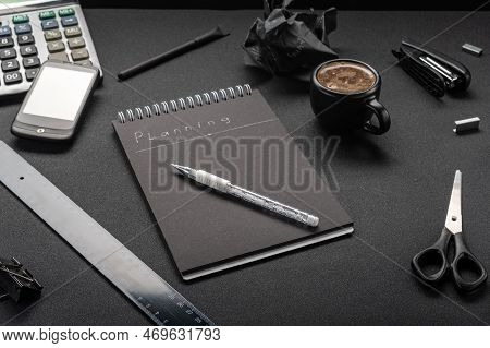 Office And Items In Black. All Items Are Black. Black Notebook And White Pen. Strong Coffee On The T