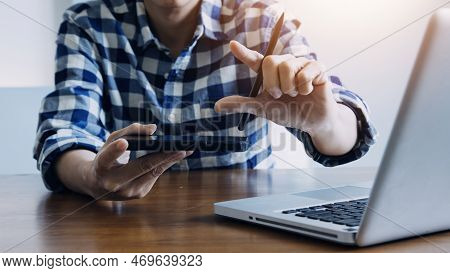 Multi-tasking Businessman Working In The Office. He Is Using Touchpad While Reading An E-mail On Lap