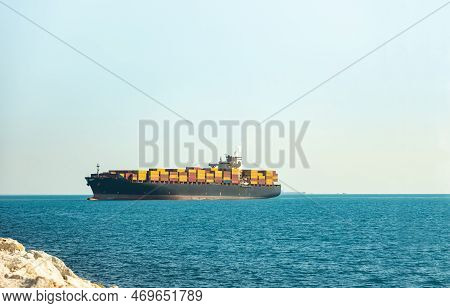 Large Cargo Container Ship Loaded With Containers Against The Blue Sky