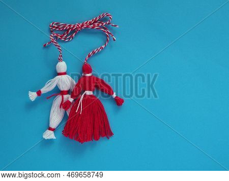 Martisor Red And White Thread Dolls On A Blue Background. Greetings Or Invitation For Holiday Martis