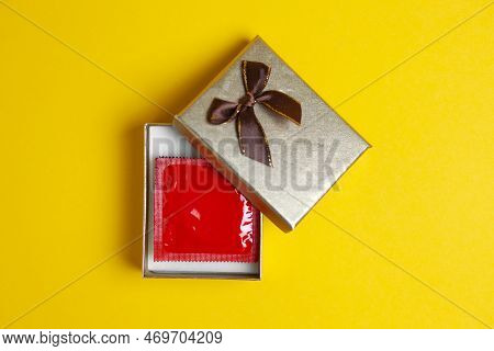 Condom In A Gift Box On A Yellow Background, Sexy Gift, Safe Sex Concept For The Holiday