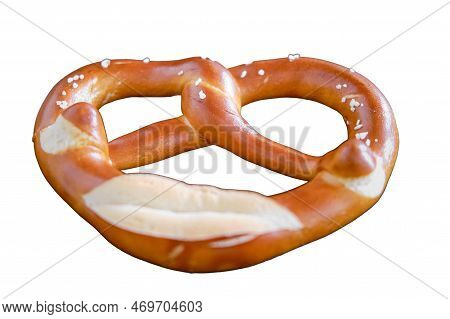 Brezel Lies In A Plate On A Wooden Table In A Cafe, Isolated On A White Background