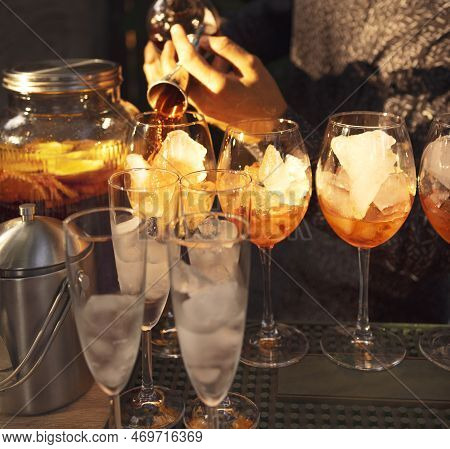 Glasses Of Cocktails On The Bar. Bartender Pours A Glass Of Sparkling Wine With Red Alcohol. Barman 