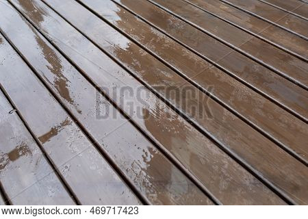 Wet Wooden Decking On The Terrace After The Rain. Background Of Wet Planks. Selective Focus.