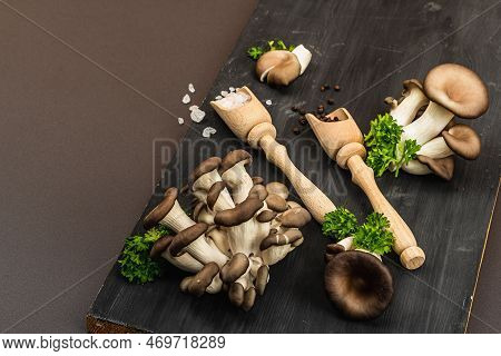 Delicious Organic Oyster Mushrooms With Spices And Fresh Parsley On Wooden Cutting Board