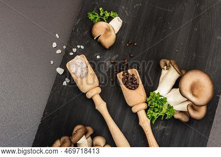 Delicious Organic Oyster Mushrooms With Spices And Fresh Parsley On Wooden Cutting Board
