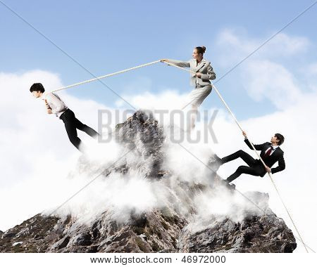Imagem de três empresários puxando a corda no topo da montanha