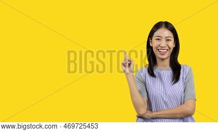 Asian woman pointing finger inviting click here, It is recommended to follow this direction or click