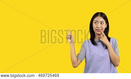 Asian woman pointing finger inviting click here, It is recommended to follow this direction or click