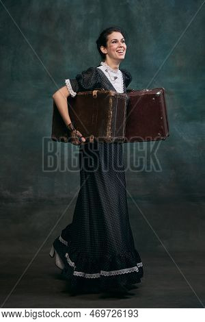 Smiling, Holding Retro Suitcases. Beautiful Woman In Image Of Anna Karenina Over Vintage Dark Green 