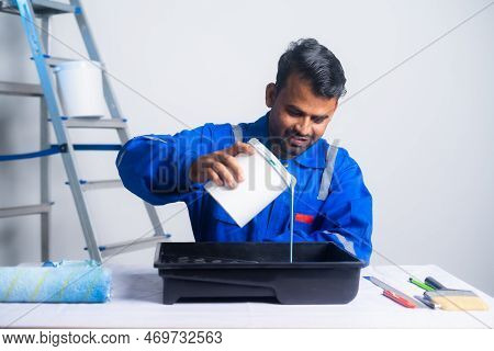 Painter Preparing For Work By Adding Paint To Box At New Home - Concept Of Preparation, Blue Coller 