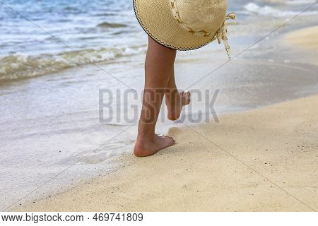 Feet Of A Sexy Tourist Walking With A Hat On A White Sandy Beach Of The Caribbean Sea In The City Of