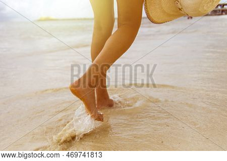 Tourist Walking With A Hat With The Sun Rays On A White Sand Beach Of The Caribbean Sea In The City