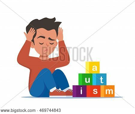 Autism Concept. Boy Feeling Lonely. Sad Boy Sitting On Floor Surrounded By Cubes Toys With Word Auti