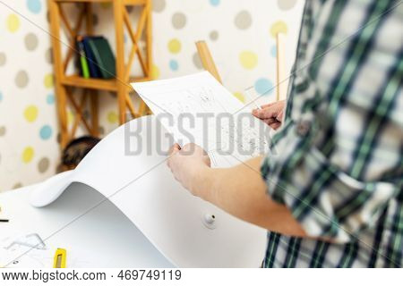 Self-assembly Furniture Concept. The Young Man Himself Assembling Chairs
