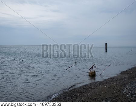Loudy Weather At Sea. An Atmosphere Of Sadness And Destruction. The Remains Of A Concrete Structure 