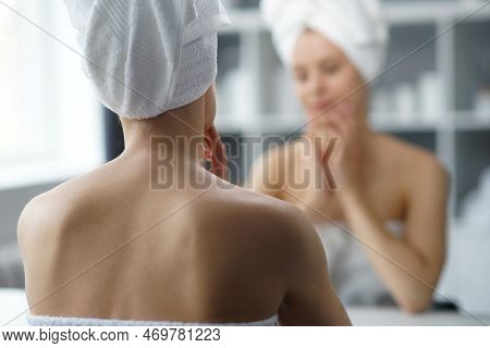 Young Woman Sits In The Bathroom In Front Of The Makeup Mirror And Does Cosmetic Procedures. Beautif