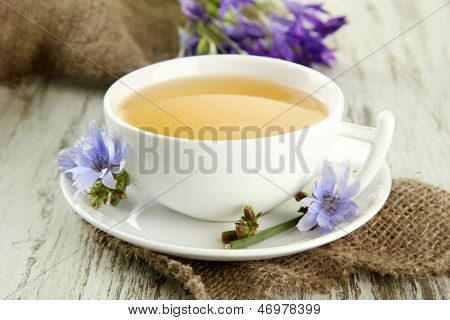 Taza de té con achicoria, sobre fondo de madera