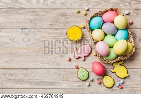 Colorful Easter Cookies In Basket With Multi Colors Easter Eggs On Colored Background . Pastel Color