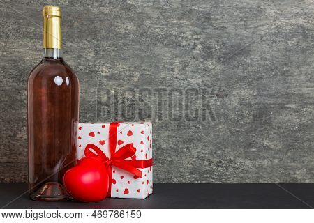 Bottle Of Wine On Colored Background For Valentine Day With Gift Box. Heart Shaped With Presrnt Box 