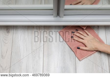A Woman Washes The Floor In A Hard-to-reach Place. Woman Doing Wet Cleaning Of The Floor In The Room