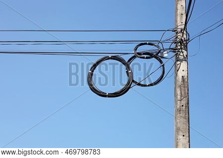 Cable Reel Hanging From A Pole. Black Reel High Speed Internet Or Fiber Optic Cable Hanging On Low V
