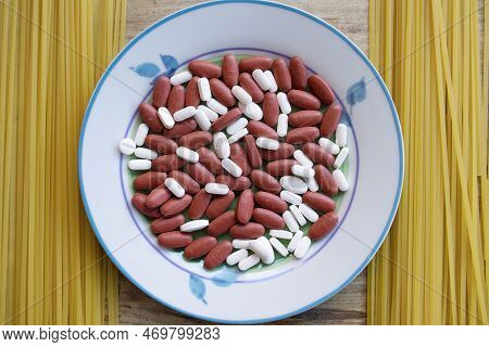 Plate With Pills Inside And Spaghetti Next To It For A Concept Of Health At The Table