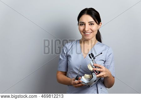 Dentist Holding Dental Articulator With Dental Gypsum Prosthesis Model In Dental Laboratory