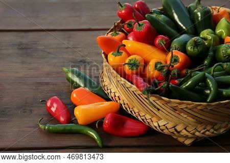 Many Different Fresh Chilli Peppers On Wooden Table, Space For Text