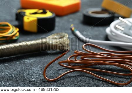 Different Electrical Wires And Tools On Black Textured Table, Closeup