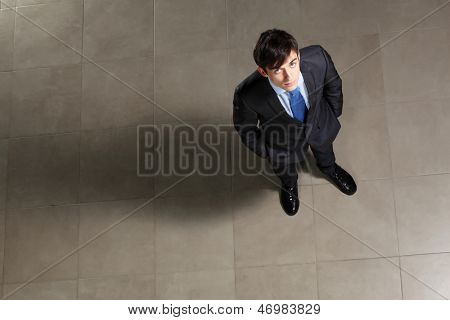 Image of young businessman looking above. Top view