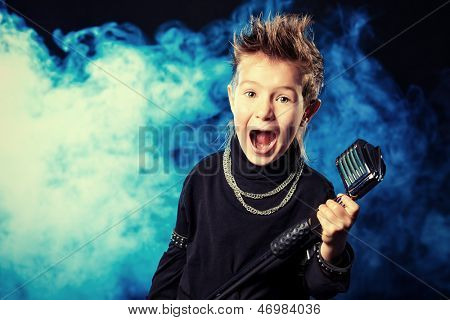 Følelsesmæssige lille dreng synger i en mikrofon ligesom en rockmusiker.