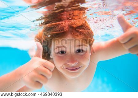 Child Face Underwater With Thumbs Up. Funny Kids Face Underwater. Underwater Boy In The Swimming Poo