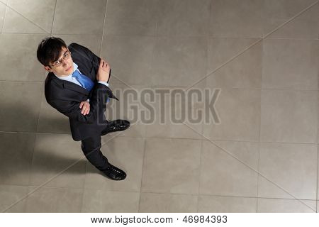 Image of young businessman in glasses arms crossed. Top view