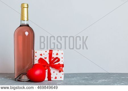 Bottle Of Wine On Colored Background For Valentine Day With Gift Box. Heart Shaped With Presrnt Box 