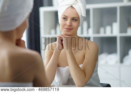 Young Woman Sits In The Bathroom In Front Of The Makeup Mirror And Does Cosmetic Procedures. Beautif