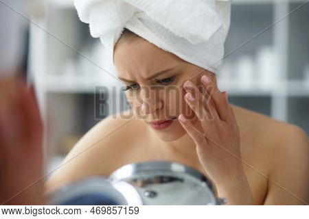 Young Woman Sits In The Bathroom In Front Of The Makeup Mirror And Does Cosmetic Procedures. Beautif