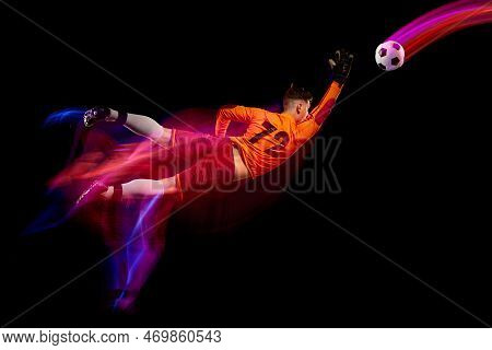 Sportive Energetic Man, Soccer Football Goalkeeper In Action, Motion Over Dark Background With Mixed