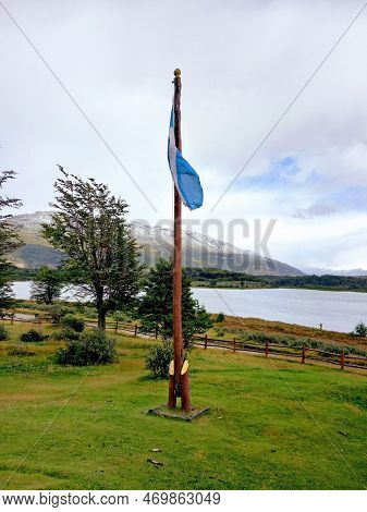 Unwaved Flag On Wooden Pole In Extreme Landscape Of Argentine Patagonia. Extreme Landscape Of Patago