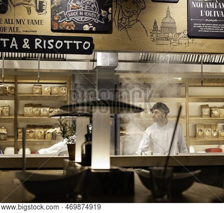 London - 02 27 2022: Chef In Kitchen At Vapiano Restaurant In Tottenham Court Road With Cooking Stea
