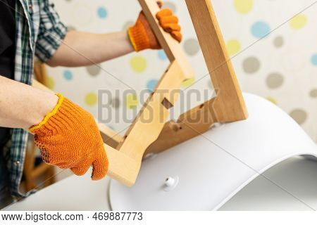 Self-assembly Furniture Concept. The Young Man Himself Assembling Chairs