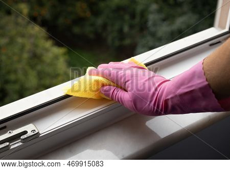 Hand Holding A Yellow Microfiber Cloth To Clean Dust On A Window Rail. High Quality Photo