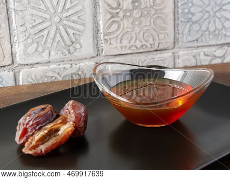Natural Organic Healthy Date Syrup In A Glass Bowl With Whole Dates On The Background. Close Up