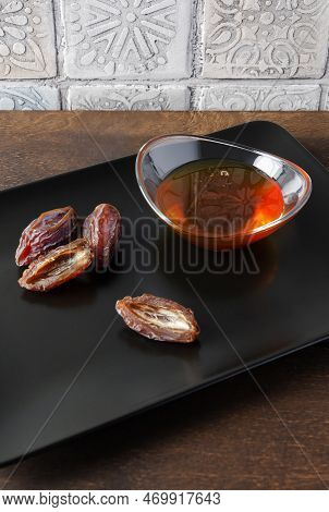 Natural Organic Healthy Date Syrup In A Glass Bowl With Whole Dates On The Background