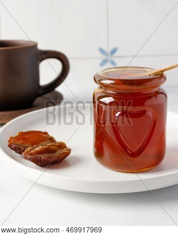 Natural Organic Healthy Date Syrup In A Glass Jar With Wood Spoon And Whole Dates And A Cap Of Tea O