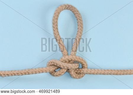Rope Knot Butterfly Loop, Also Known As Swiss Loop Tied With A Climbing Rope On A Blue Background
