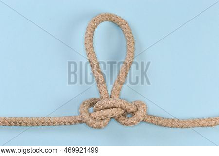 Rope Knot Butterfly Loop, Also Known As Swiss Loop Tied With A Climbing Rope On A Blue Background
